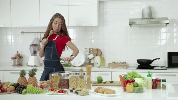 The young woman entered the kitchen, made the meal and danced in joy, fun in the routine