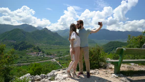 Couple Taking Selfie From a Hill Overlooking the Mountains