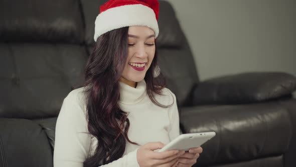 woman in santa hat using digital tablet in the living room