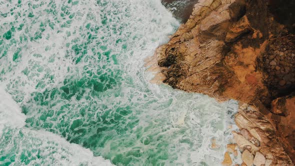 Sea Waves Beat Against Steep Cliff on Sunny Day Slow Motion alt