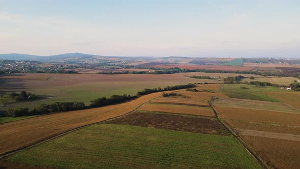 Ukrainian fields stretch on the hills near the settlements Aerial view