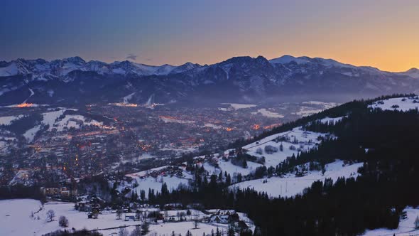 Dusk over snowy zakopane in winter at night, aerial view alt