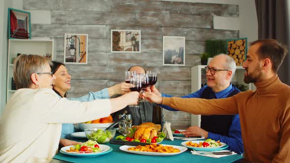 Happy Family During Lunch Toasting with Red Wine alt