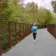 Female Jogger with Headphones Running on Bridge in Park - VideoHive Item for Sale