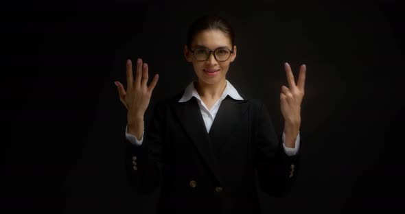 Business Woman Smiles at the Camera and Shows the Number Seven with Her Fingers