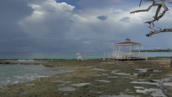 Wooden pavilion and a statue on the beach alt