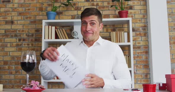 Caucasian man making video call holding handwritten sign making marriage proposal and celebrating ac alt
