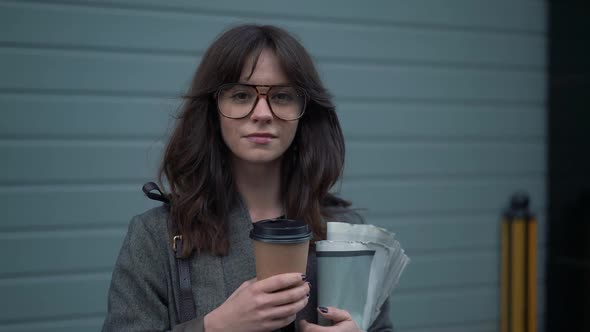 Slow Motion Pan Shot of Business Woman in Eyeglasses with a Cup of Coffee