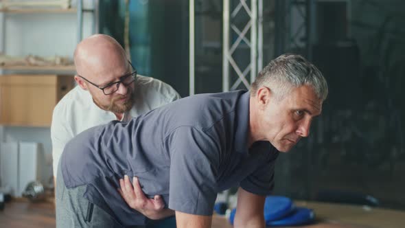 Physiotherapist Conducting a Rehabilitation SessionFor a Man with a Brain Stroke alt
