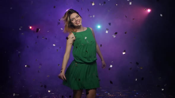 Dancing of Young Woman in Green Dress, Under Falling Confetti alt