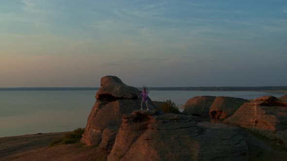 A Girl Does Fitness on a Hill at Sunset alt