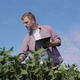 A Young Farmer Makes Notes in a Tablet About the Peculiarities of Soybean Growth in the Field - VideoHive Item for Sale
