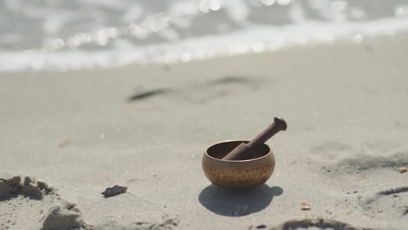 Bronze Tibetan Singing Bowl for Meditation on the Sandy Sea Beach alt