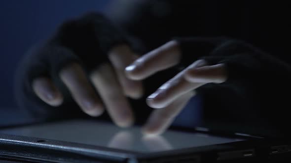 Closeup of Criminal's Hands Scrolling Pages on Tablet Touchscreen, Cybercrime alt