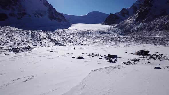 One Climber Is Walking Among the Snowy Mountains alt