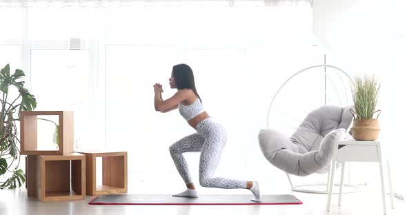 Athletic fit girl doing fitness aerobic exercises for booty in living room. alt