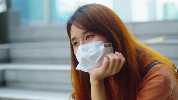 Young asian woman wear medical mask fell bored, stress and  loneliness during virus pandemic