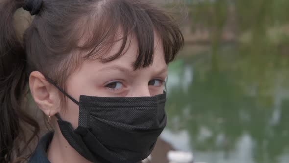 Child in mask in the street.  alt