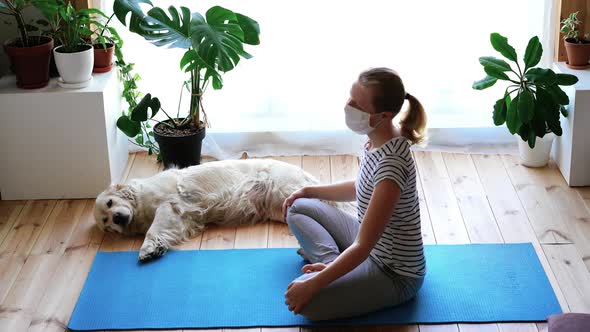 Stay at Home. Woman Doing Yoga in the Living Room During Quarantine, a Large Dog Is Lying Nearby.
