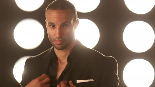 Handsome and stylish man in front of a wall of lights alt