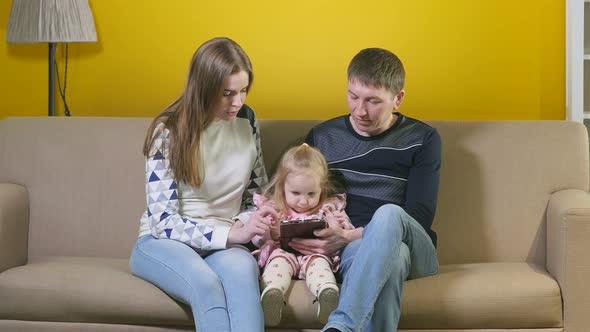Portrait Of A Young Family On The Couch