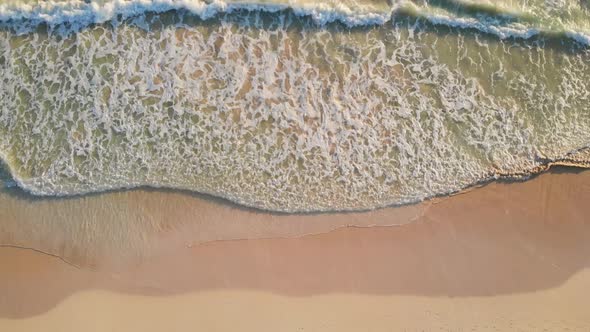 Aerial View of Ocean Blue Waves Break on a Beach