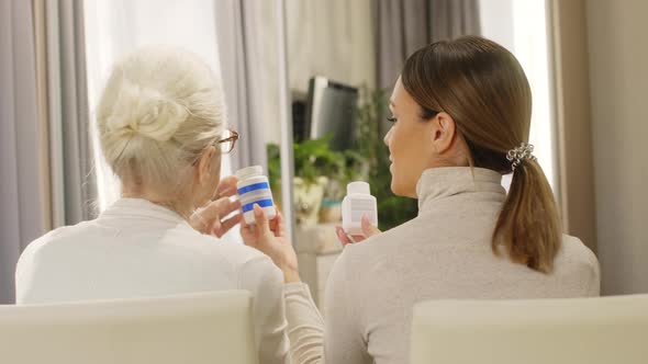 Young Woman Reading Prescription on Pills to Grandmother