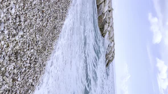 Sea Wave on Stone Beach in summer with white foamy on summer. Nature with sea and beach. travel or