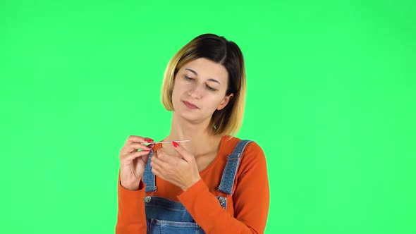 Girl Makes Herself Manicure with Pink Nail File. Green Screen alt