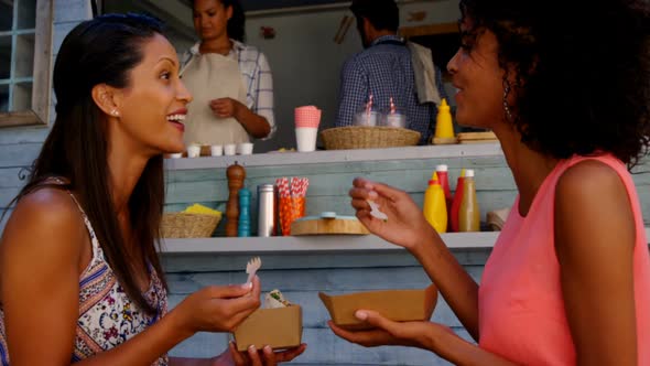 Smiling friends eating snacks alt