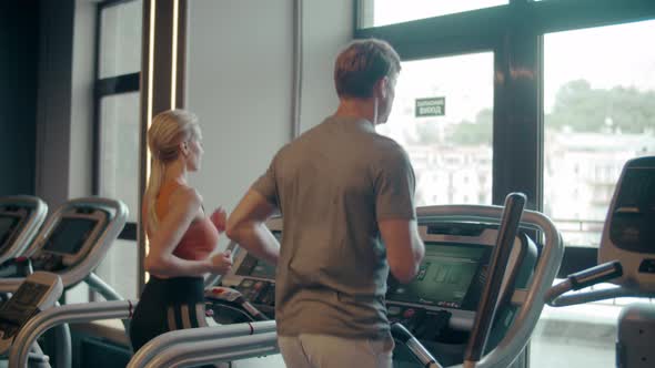 Fit Couple Running on Treadmill at Gym. Sporty Family Doing Cardio in Sport Club alt