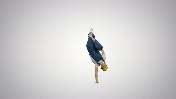 Young Construction Worker in Yellow Hardhat Break Dancing on His Hands and Smiling at Camera at the alt