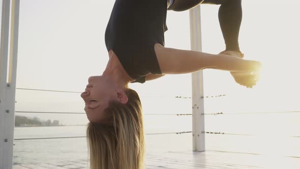 Woman Does Exercises Hanging Upside Down on Yoga Sling