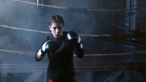 Female Boxer Training in the Dark Ring alt