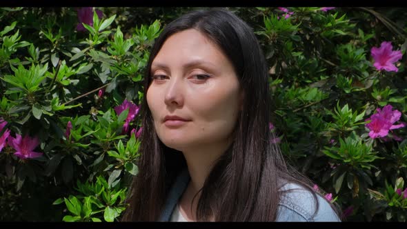 Female Face on the Background of Blooming Tree