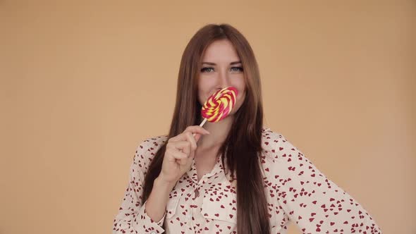 Young Beautiful Girl Holding Big Lollipop and Flirting