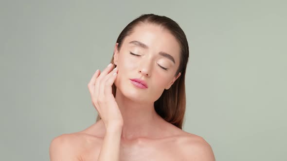 Beautiful Young Woman with Clean Fresh Skin Standing Over Light Grey Background alt