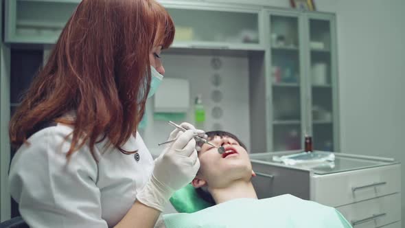 Female dentist working in her dentist office. Dental clinic. Reception, examination of the patient. alt