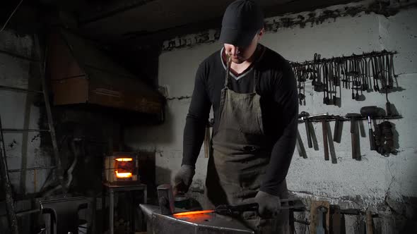 A Man Blacksmith Working with a Hot Metal alt