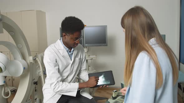 African American Family Medical Doctor in Modern Clinic Holding Tablet Pc and alt