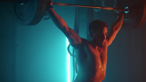 Young Powerlifter is Training with Barbell in Gym Lifting Weight and Lowering on Floor alt
