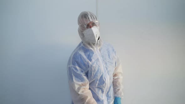 Exhausted Worker of Disinfection Service is Undressing After Work alt