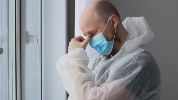 A Tired Doctor After a Shift in the Infectious Diseases Department with Coronovirus Patients Stands alt