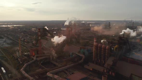 Aerial View. Pipes Throwing Smoke in the Sky. Large Plant on the Background of the City.