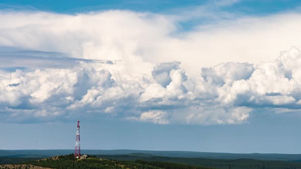 Movement of Cumulus Clouds Behind a Hill with a TV Tower on Top alt