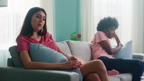 Women Friends Sit On Sofa After Conflict alt