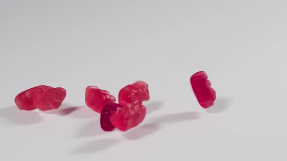 Gummy Bears falling onto a white surface in slow motion alt