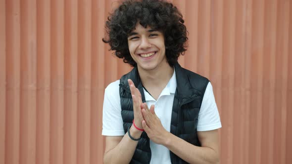 Slow Motion of Excited Middle Eastern Guy Rubbing Hands and Looking at Camera Outdoors alt