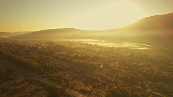 Cinematic Aerial Drone View of Hazy Mountain Walley at Sunrise alt