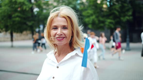 Slow Motion Portrait of Pretty French Lady Holding Flag of France Outdoors alt